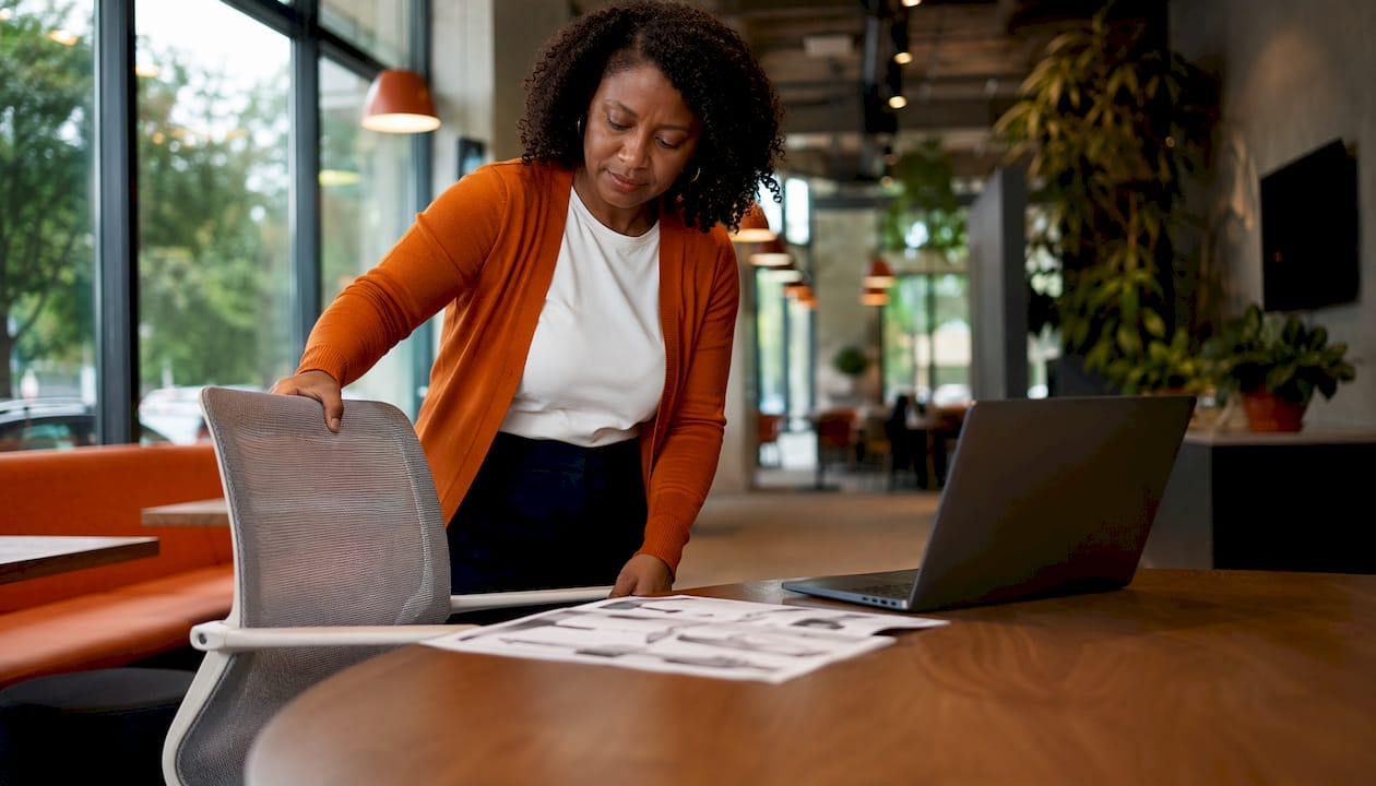 Woman adjusting ergonomic chair in office