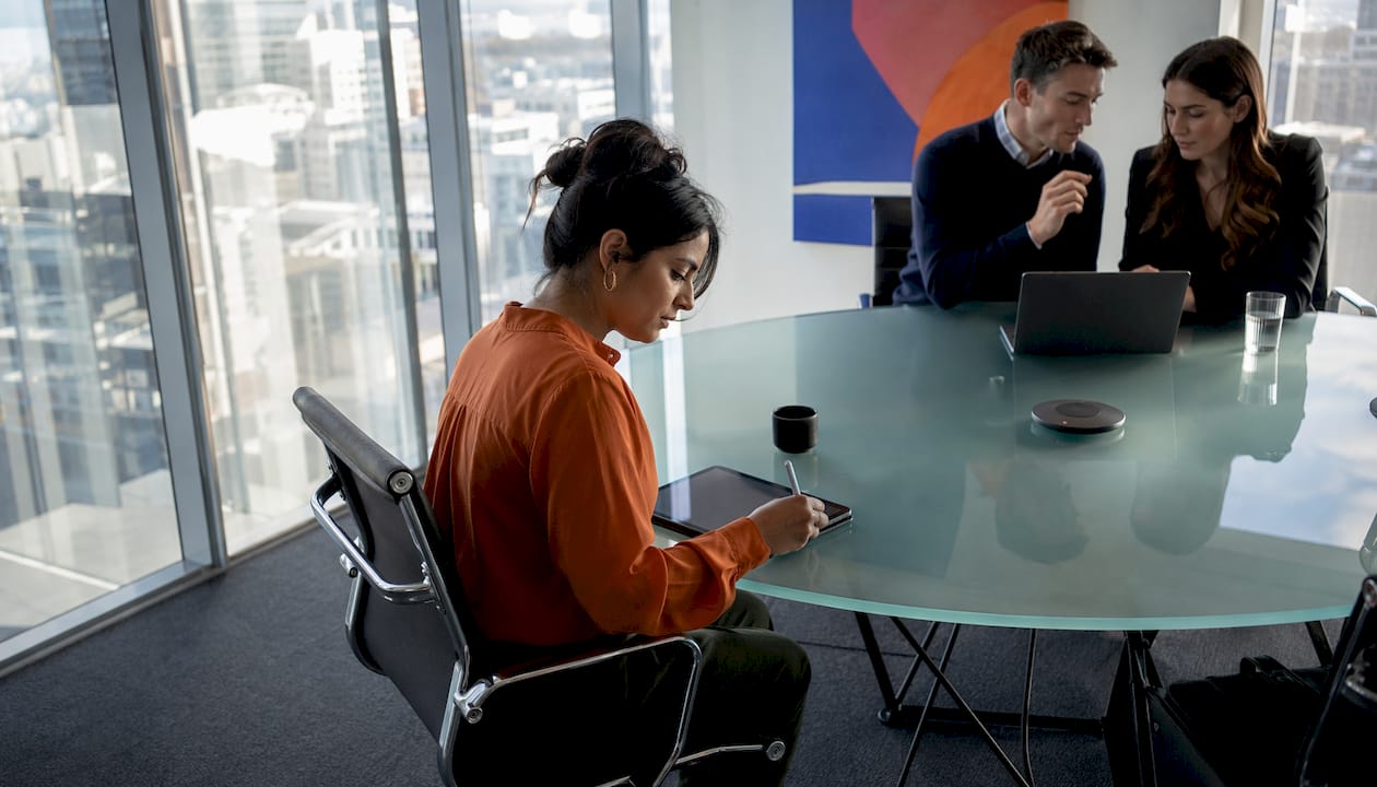 Woman taking notes in UK office meeting