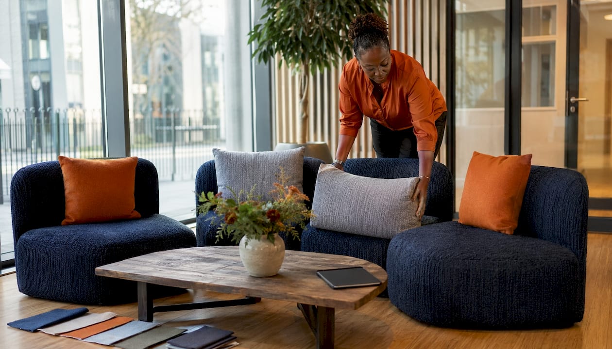 Office manager arranging client lounge seating
