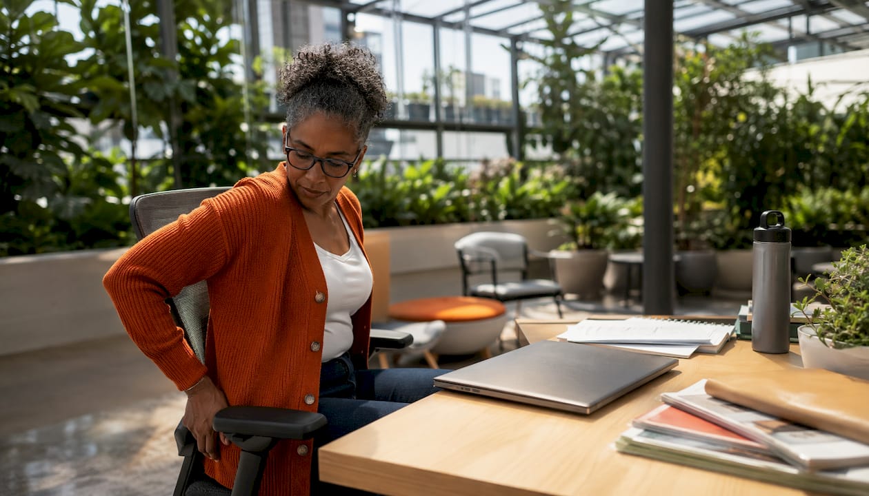 Woman adjusting ergonomic task chair in office