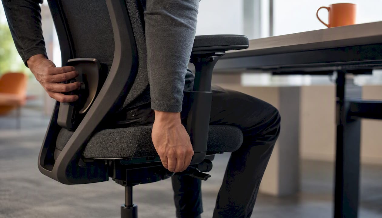 Hands adjusting ergonomic office chair settings
