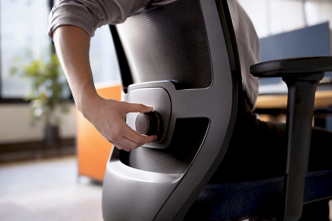 Hand adjusting lumbar support knob on office chair