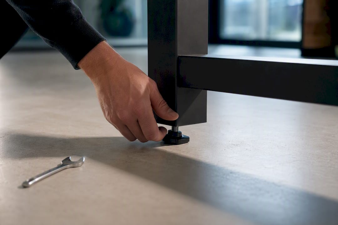 Hand adjusting standing desk foot